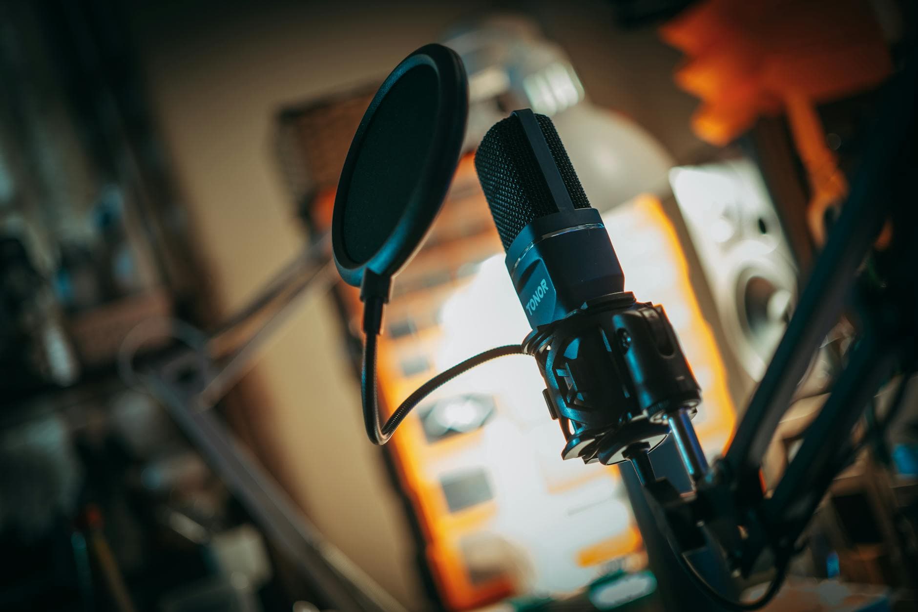 Close-up of a microphone with pop filter in a recording studio, perfect for music production visuals.
